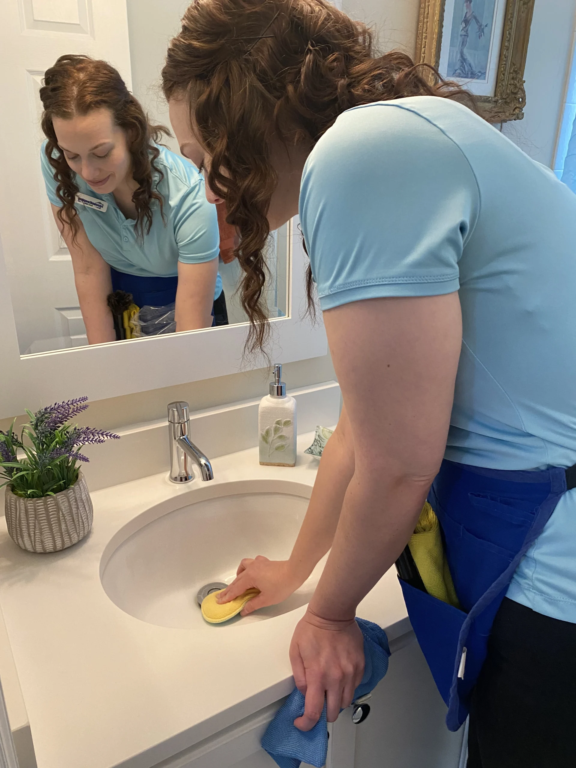 Expert cleaning technician scrubbing bathroom sink during detailed move-in cleaning service.